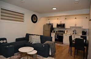 A modern kitchen with white cabinets, a microwave, and a stove. - Luxury 2BR Apartment | Relax, Unwind, Indulge (Edmonton)