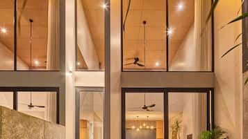 Ein modernes Interieur mit Treppe, Deckenventilatoren und einem Essbereich.