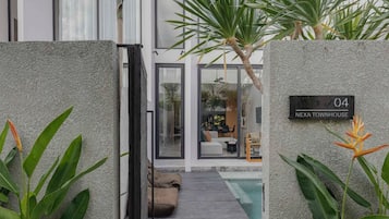 Una casa moderna con piscina, un cartel que indica 'NEXA TOWNHOUSE' y el número '04' en la pared.