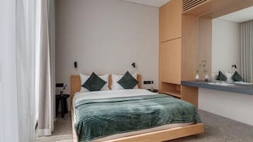 Un dormitorio moderno con estructura de cama de madera, un espejo grande y una mesita de noche pequeña.
