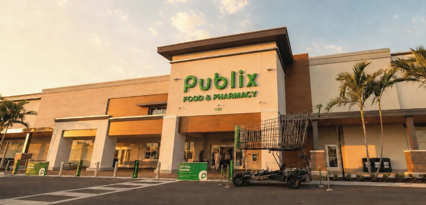 Un magasin Publix, qui vend des produits alimentaires et des médicaments, avec une grande enseigne, un parking et un chariot de courses à l'extérieur.