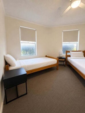 A room with two single beds, a small table, and a window. - Ground Floor Beachfront Escape, Pool Views,Surfside Resort (Sunshine Coast)