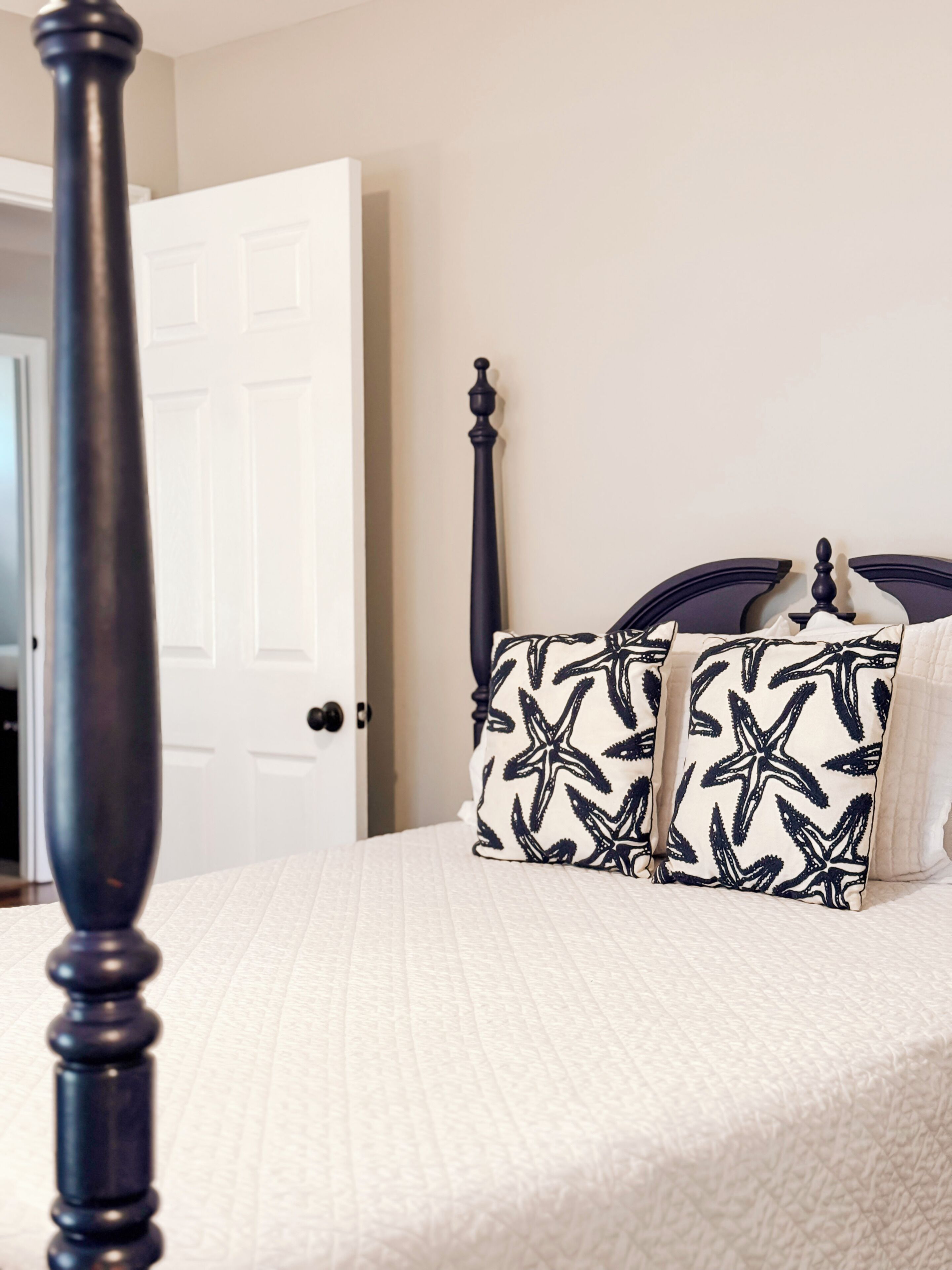 A bedroom with a bed, a door, and a window.