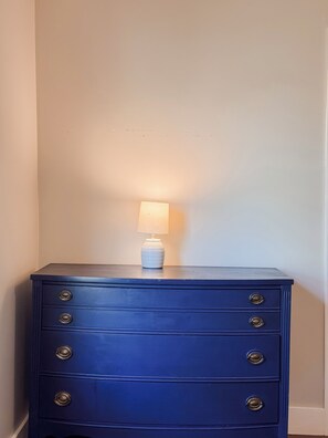 A dark blue dresser with four drawers and a white lamp on top. - Waterfront Beaufort Home - Sunset Views Near Parris Island (Beaufort)