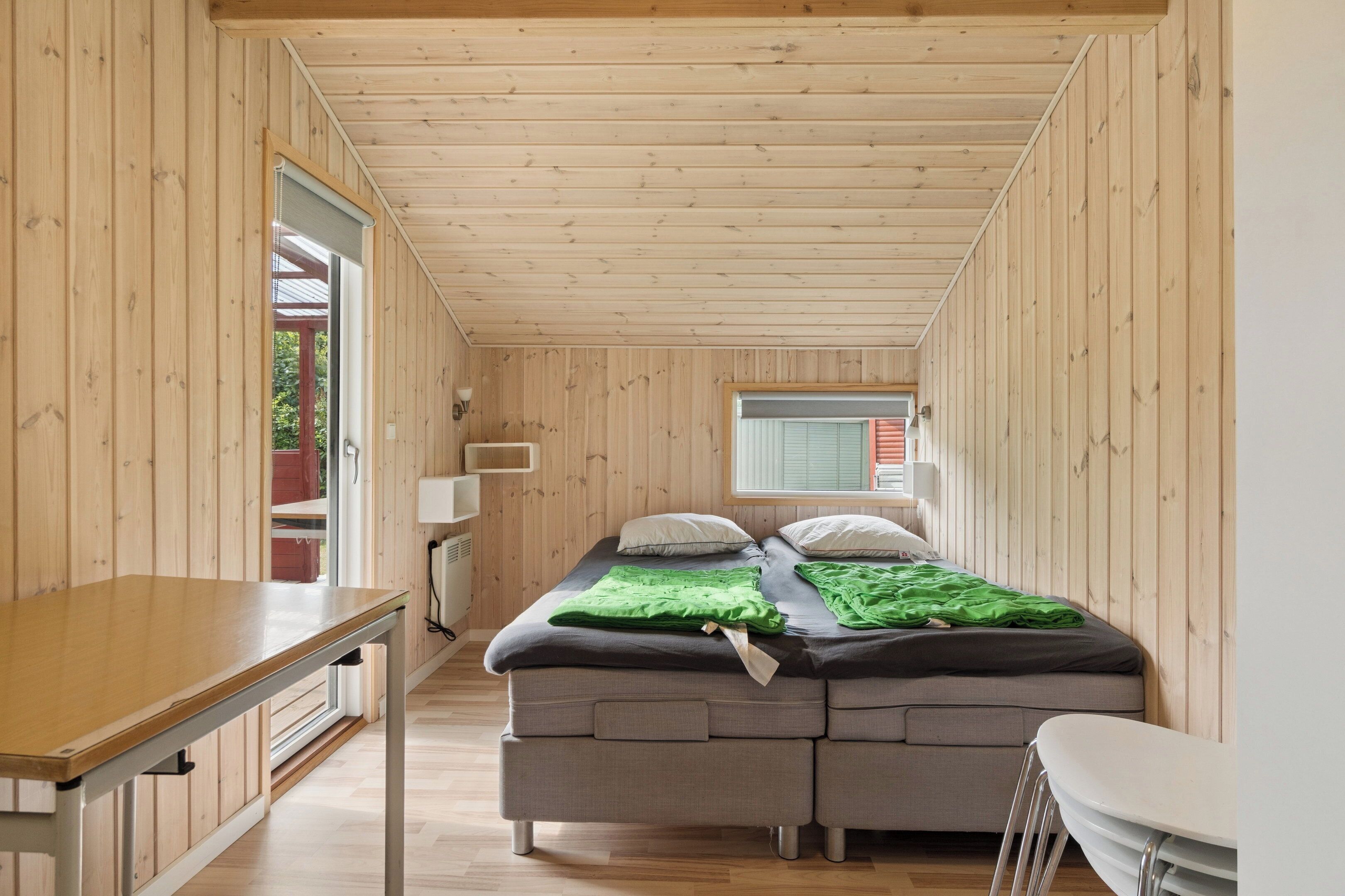 A compact room with a bed, a table, and a window.