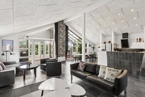 Ein modernes Interieur mit einer Sitzecke, einem Kamin und Blick durch große Glasüren.