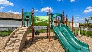 A playground with a slide, climbing steps, and a green climbing structure. - 3BR Luxury North Retreat with Pool and Gym (Naples)