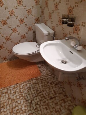 A bathroom with a toilet, sink, and patterned tiles. - Wohnung Bergruh Appartement/Fewo, Dusche, WC 2-Bettwohnung by Interhome (Rosswald)