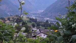 Ein Tal mit Häusern und Bergen im Hintergrund.