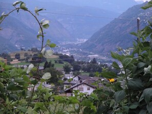 Ein Tal mit Häusern und Bergen im Hintergrund.
