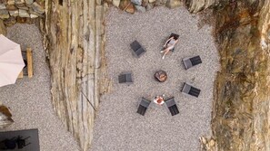 Un espacio al aire libre con seis sillones de descanso y una chimenea.