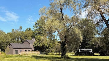 A house with a large lawn and a volleyball net.