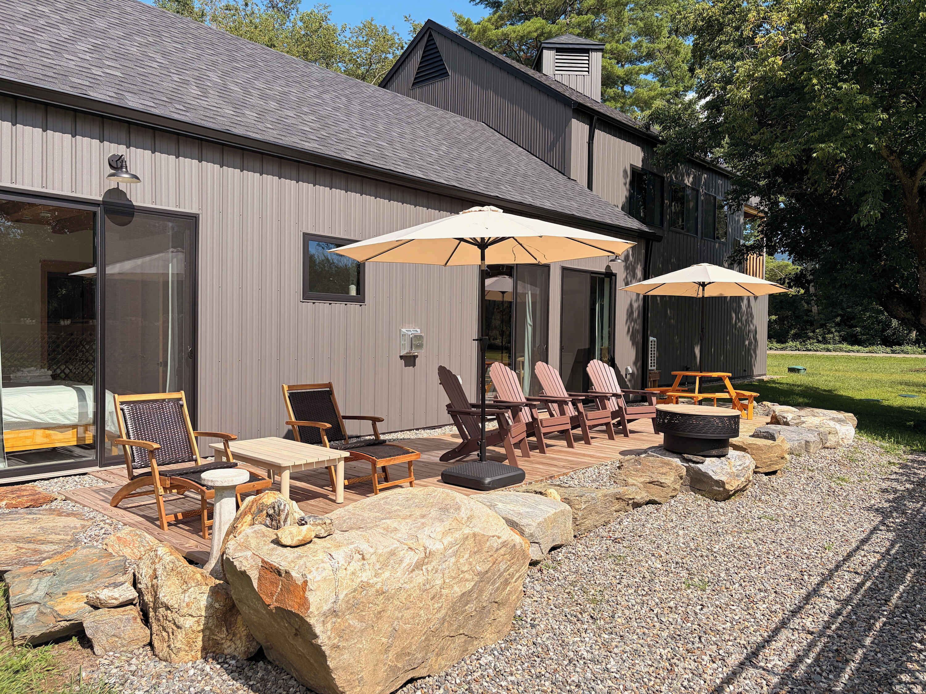 A modern building with a patio area featuring outdoor seating and a fire pit.