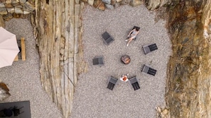 Un espacio al aire libre con seis sillones de descanso y una chimenea.