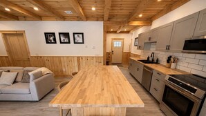 Eine moderne Küche mit Holzboden, einer zentralen Kochinsel und eingebauten Geräten.