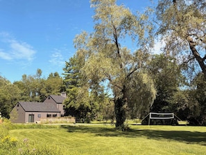 A house with a large lawn and a volleyball net. - Bear Hearth | Nordic Barn, Stowe Nature Escape (Stowe)
