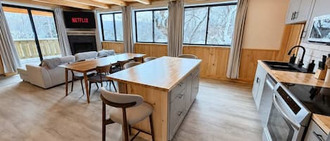 Une cuisine moderne avec des meubles en bois, un îlot central et un four encastré.