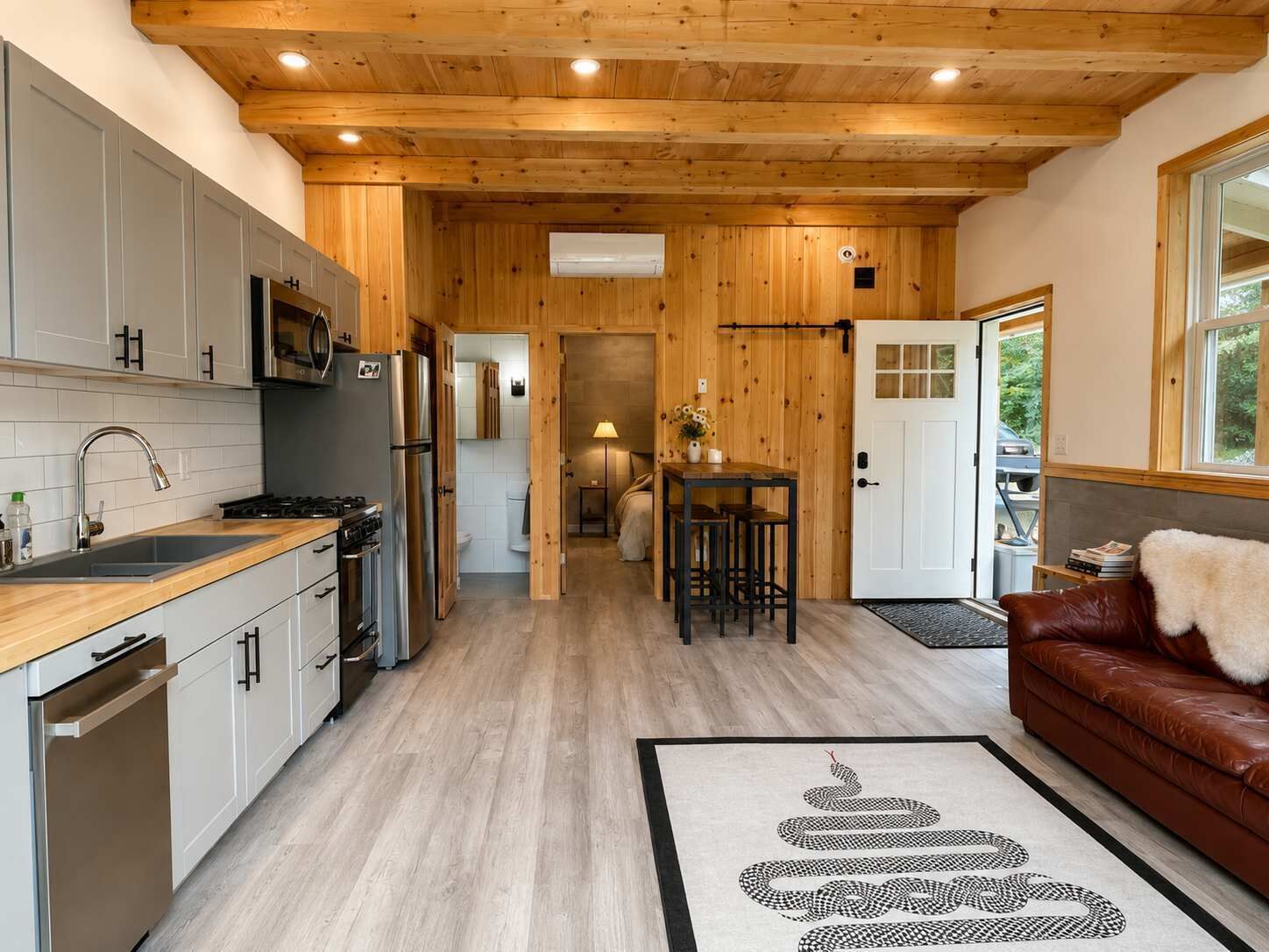 A modern kitchen with wooden cabinetry, a stainless steel refrigerator, and a built-in oven.