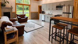 Una cocina moderna con gabinetes grises, electrodomésticos de acero inoxidable y techo de madera.