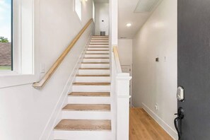 A staircase with wooden steps and white railings leading to a landing. - Music-Themed Nashville Home | 4BR, 4 Baths & Bunk (Nashville)