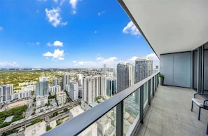 A high-rise balcony with a city view, modern architecture, and a clear sky. - Brickell Skyline with Rooftop Pool & Spa (Miami)