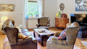 A living room with leather sofas, a coffee table, a television, and a decorative cabinet. - Vacation home JANIKE by Interhome (Regensburg)