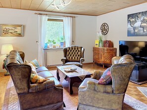 A living room with leather sofas, a coffee table, a television, and a decorative cabinet. - Vacation home JANIKE by Interhome (Regensburg)