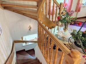Eine Holztreppe mit einem Glastisch und einem Blumenstrauß.