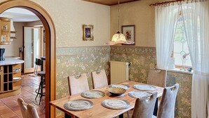 A dining area with a wooden table set for six, surrounded by chairs. - Vacation home JANIKE by Interhome (Regensburg)