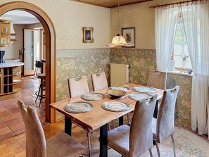 A dining area with a wooden table set for six, surrounded by chairs. - Vacation home JANIKE by Interhome (Regensburg)