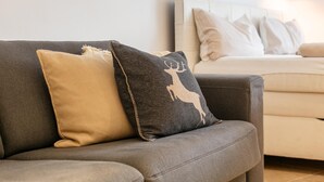 Ein graues Sofa mit zwei Kissen, eines mit einem Hirschmuster und das andere schlicht.