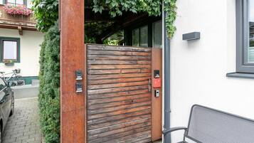 A wooden gate with a metal handle, a bench, and a bicycle parked nearby.