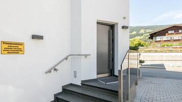Entrada de un edificio con una escalera, una puerta y un letrero que indica propiedad privada.