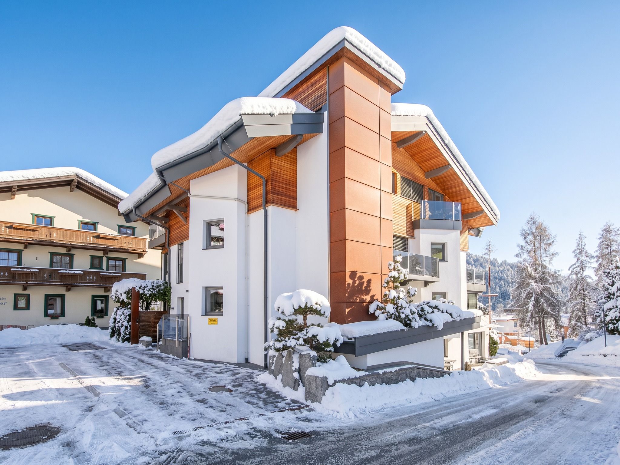 Un bâtiment moderne avec un toit enneigé et une conception à pente.