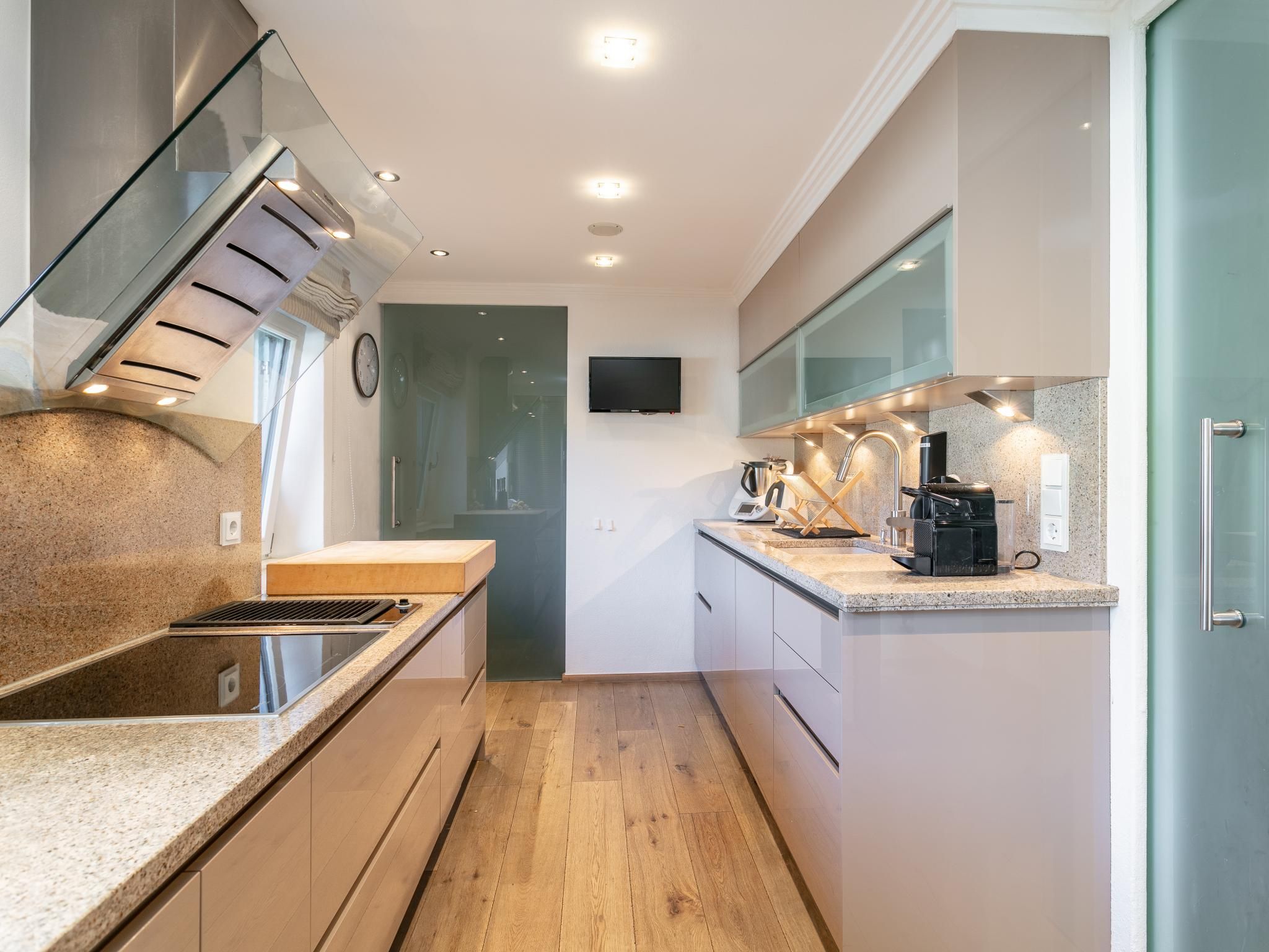 Een moderne keuken met een inbouwfornuis, een magnetron en een koffiezetapparaat.