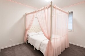 Une chambre à coucher avec un lit à baldaquin, une fenêtre avec des stores et un plancher recouvert de moquette.