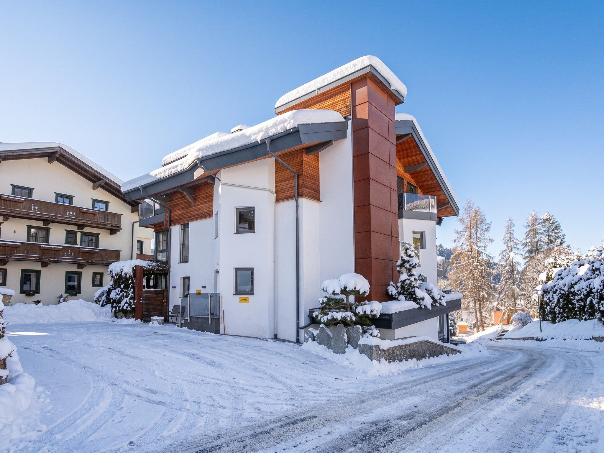 Un bâtiment moderne à deux étages, avec un toit enneigé et un ciel dégagé.