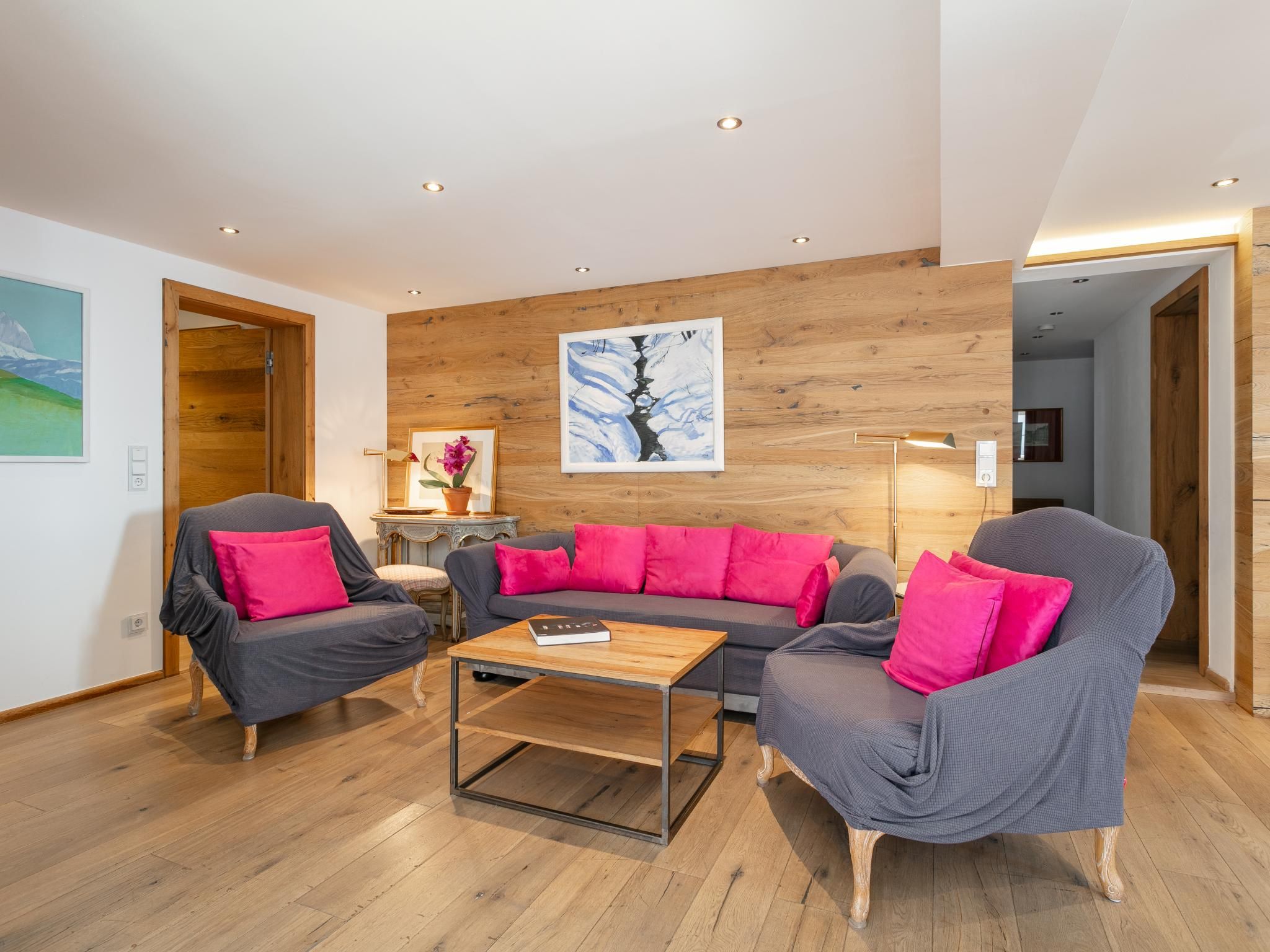 Un salon moderne avec un mur en bois, un ensemble de canapés et une table basse.
