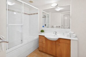 A bathroom with a shower, a sink, and a mirror. - Turtles -Water Park Resort - Mermaid Beach (Mermaid Beach)