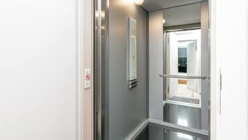 Een moderne lift met een digitaal scherm en een leuning.