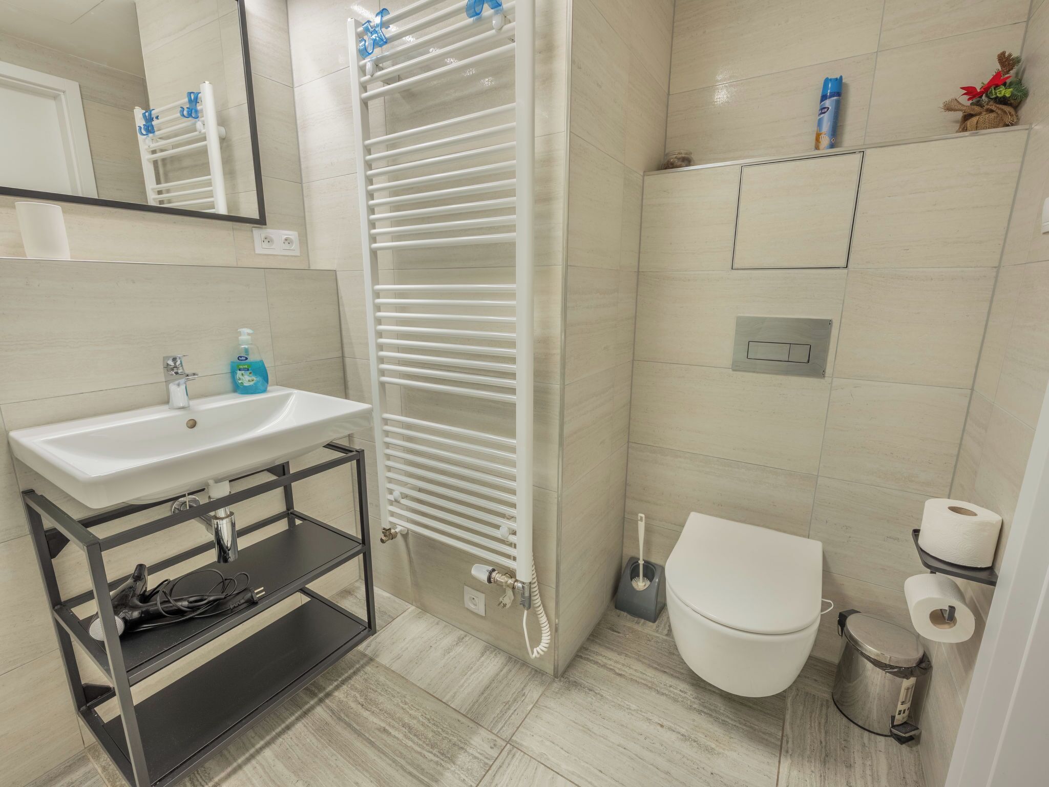 Un baño moderno con lavamanos, inodoro y ducha blancos.