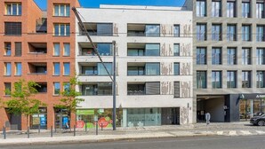 Edifici d'altes plantes amb façana de maó i disseny modern, amb balcons i finestres grans.