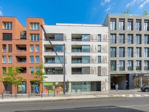 Ein mehrstöckiges Gebäude mit Ziegel- und moderner Fassade, mit Balkonen und großen Fenstern.