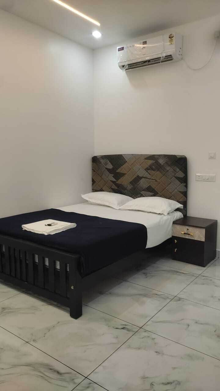 Quarto com cama, mesa de cabeceira e ar condicionado.