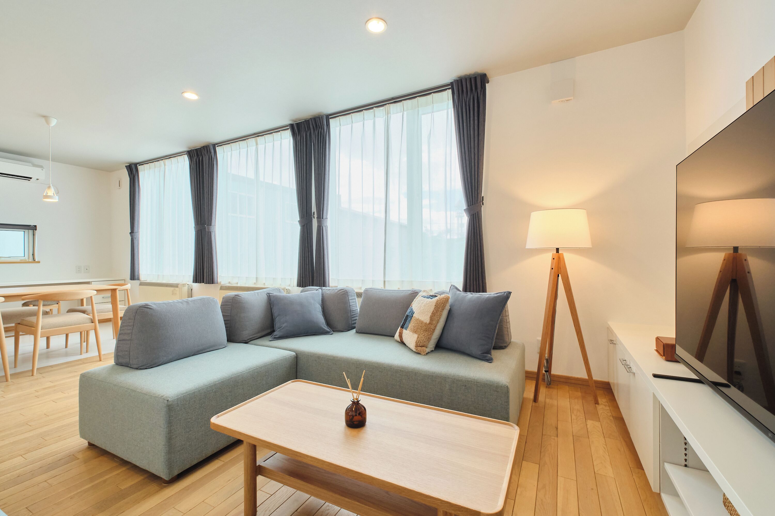 A modern living room with a sectional sofa, a small table, and a TV.