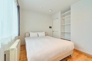 A bedroom with a bed, a wardrobe, and a radiator.