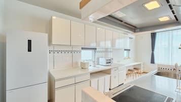 A modern kitchen with white cabinetry, a built-in microwave, and a stove.