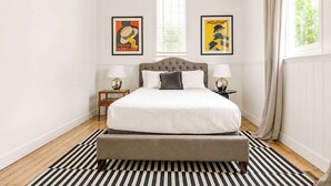 Ein Schlafzimmer mit einem großen Bett, zwei Nachttischen und zwei Wandleuchten.