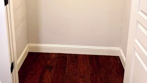 A room with a wooden floor, white walls, and a door with a white frame. - CasaDeCarrion: 30+Day Extended Corporate Stay Fully Furnished 3bd/2.5ba (San Antonio)