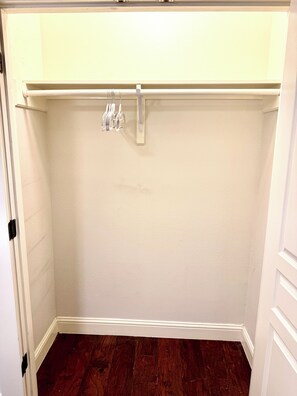 Ein Zimmer mit Holzboden, weißen Wänden und einer Tür mit weißem Rahmen.
